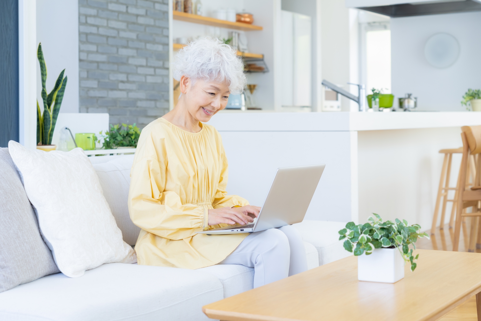 リビングでパソコンを見るシニアの女性